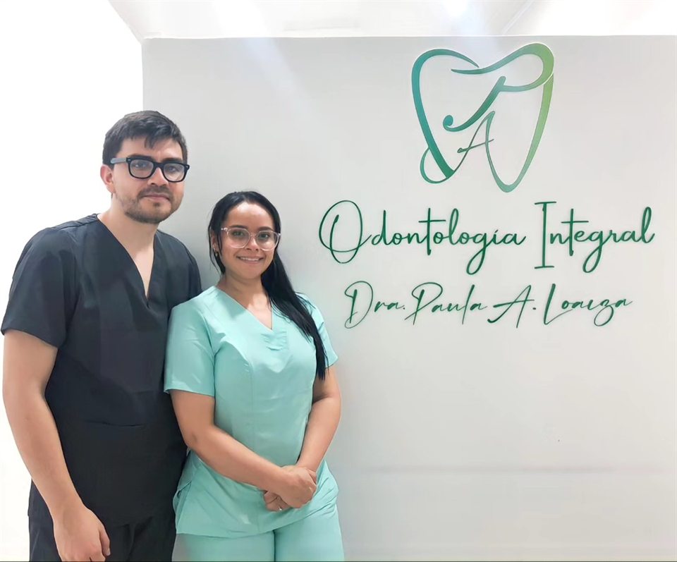 Dr. Alejandro Leal V. y Dra. Paula A. Loaiza frente al logo del consultorio